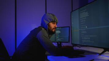 Hacker in hoodie writing code and conducting cyber attack video