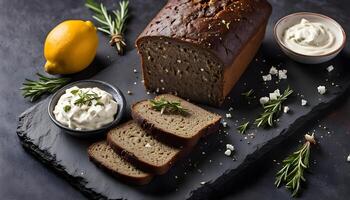 Pumpernickel bread with feta, cream cheese, rosemary, lemon and garlic dip, on slate board, top view, horizontal photo