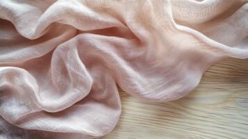 Elegant pink fabric with delicate folds on wooden background for textile concept photo