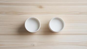 Two white ceramic cups on wooden background with minimalist design concept photo