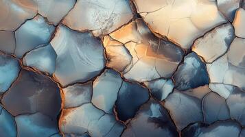 Cracked earth texture with abstract patterns highlighted by soft sunlight photo