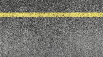 Close-up of asphalt road surface with yellow line for traffic guidance concept photo