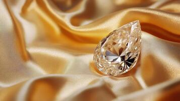 Sparkling teardrop diamond on luxurious golden silk fabric background photo