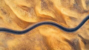 Aerial view of winding road through barren desert landscape captured in daylight photo
