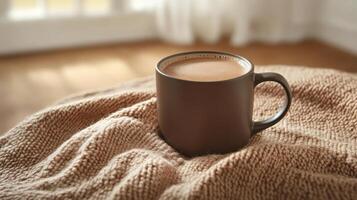 Warm coffee mug on cozy knit blanket in sunlit room creating comfort photo