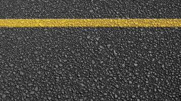Close-up of asphalt road with single yellow line for transportation concept photo
