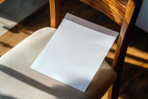 Blank sheet of paper placed on a cushion chair with sunlight streaming through photo