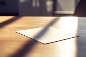 Sunlit wooden table with single sheet of paper casting shadows photo