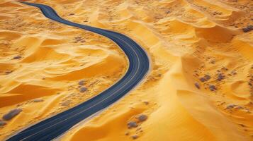Winding road through vast desert landscape with golden sand dunes and blue sky photo