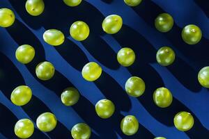 Green grapes pattern on dark blue background with shadows and light play photo