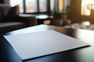 Empty white paper on a dark wooden table in a sunlit room setting photo