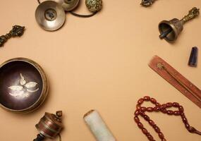 Tibetan singing copper bowl with a wooden clapper on a brown background, objects for meditation and alternative medicine. photo