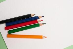 Multicolored wooden pencils on white background, top view. photo