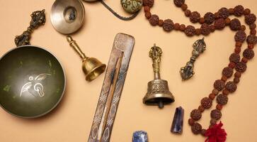 Tibetan singing copper bowl with a wooden clapper on a brown background, objects for meditation and alternative medicine. top view photo