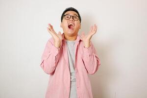 Asian man gasping with hands open and looking to copy space isolated on white background photo