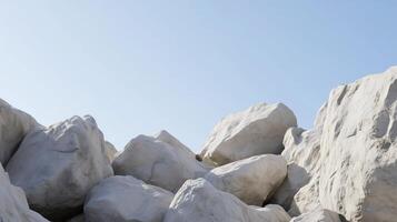 A rocky hillside with a clear blue sky in the background. The rocks are large and scattered, creating a sense of ruggedness and isolation. The scene evokes a feeling of solitude and tranquility photo