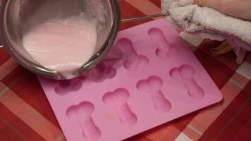 ice cream is made from melted sugar, sweet white chocolate or cream in molds for freezing in freezer in the form of small penis. Slow motion video