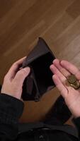 Man showing empty wallet and few coins in hand, poverty concept video