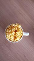 A small bowl of macaroni and cheese on a table photo