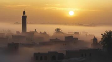 A serene sunrise over a misty landscape featuring buildings and a tower photo