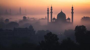 A serene silhouette of a mosque at dawn, surrounded by mist and soft colors photo