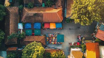 Aerial view of a vibrant market square with colorful tents and surrounding buildings. photo