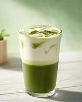 A refreshing layered green tea drink with milk and ice, served in a clear glass. photo