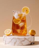 A pitcher of iced tea with lemon slices on a marble stand, perfect for refreshing drinks. photo