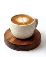 A latte art coffee in a speckled cup on a wooden coaster. photo