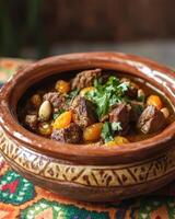 A rich meat stew served in a decorative clay pot, garnished with herbs and vegetables. photo