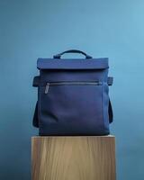 A sleek navy backpack displayed on a wooden pedestal against a blue background. photo