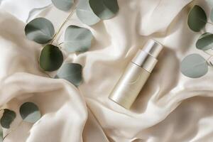 A skincare bottle on soft fabric surrounded by eucalyptus leaves photo