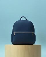 A sleek navy backpack displayed on a wooden pedestal against a soft blue background. photo