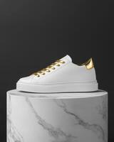 A stylish white sneaker with gold accents displayed on a marble pedestal. photo