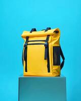 A vibrant yellow backpack against a blue background, designed for everyday use photo