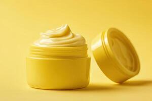 A yellow cosmetic cream in a jar, showcasing a smooth, creamy texture photo