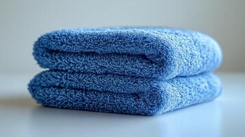 A stack of blue towels on a white surface photo