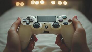 A person holding a game controller on a bed photo