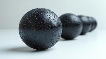 Black Spheres with Water Drops on White Background photo