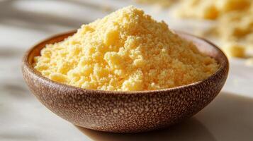 A bowl of yellow powder sitting on a table photo
