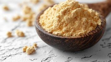 A spoon full of yellow powder on a white background photo