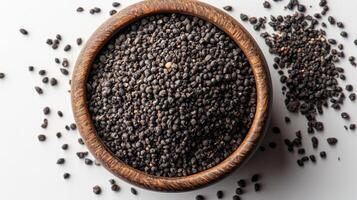 Black mustard seeds in a wooden bowl photo