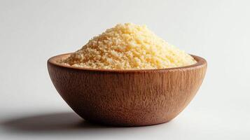 Uncooked Couscous in a Wooden Bowl on White Background photo