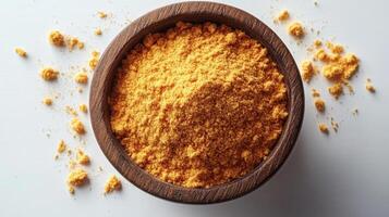 A bowl of orange powder on a white surface photo