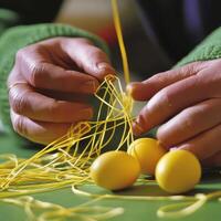 A person is tying yellow string around a bunch of yellow eggs photo