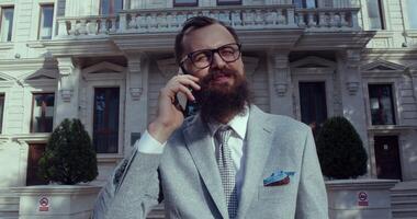 A stylish businessman is conversing on the phone in a sophisticated environment video