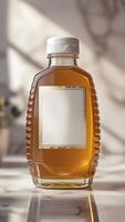 Elegant honey packaging showcases rich color and texture against marble, suggesting premium quality and natural sweetness. photo