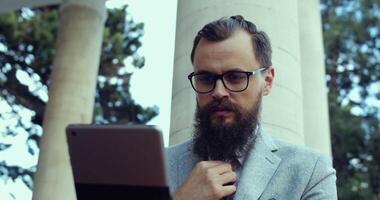 A Focused and Committed Professional Working Outdoors While Utilizing a Tablet Device video