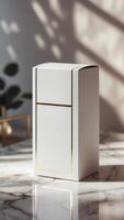 Elegant white box with gold trim standing on a luxurious marble surface, bathed in soft natural light and shadowed foliage. photo