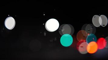 Rain bokeh road lights. Abstract shot of evening city traffic bokeh. Multicolored lights of the evening city and passing cars through a wet rainy window. video